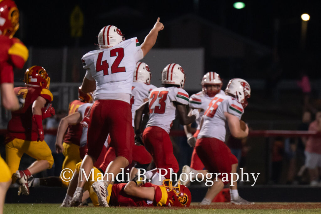 Effingham High School's Hank Nelson (55) gathers up a fumble as his teammates prepare to escort him to the end zone Friday at Charleston High School.