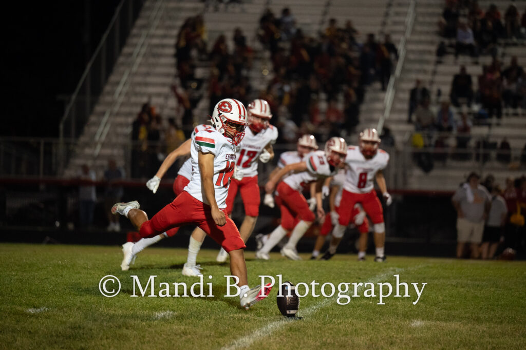 Effingham High School's Hank Nelson (55) gathers up a fumble as his teammates prepare to escort him to the end zone Friday at Charleston High School.